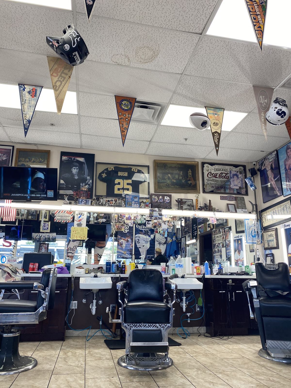 Inside Ray's Barber Shop: classic barber chairs, mirrors and walls covered in sports memorabilia